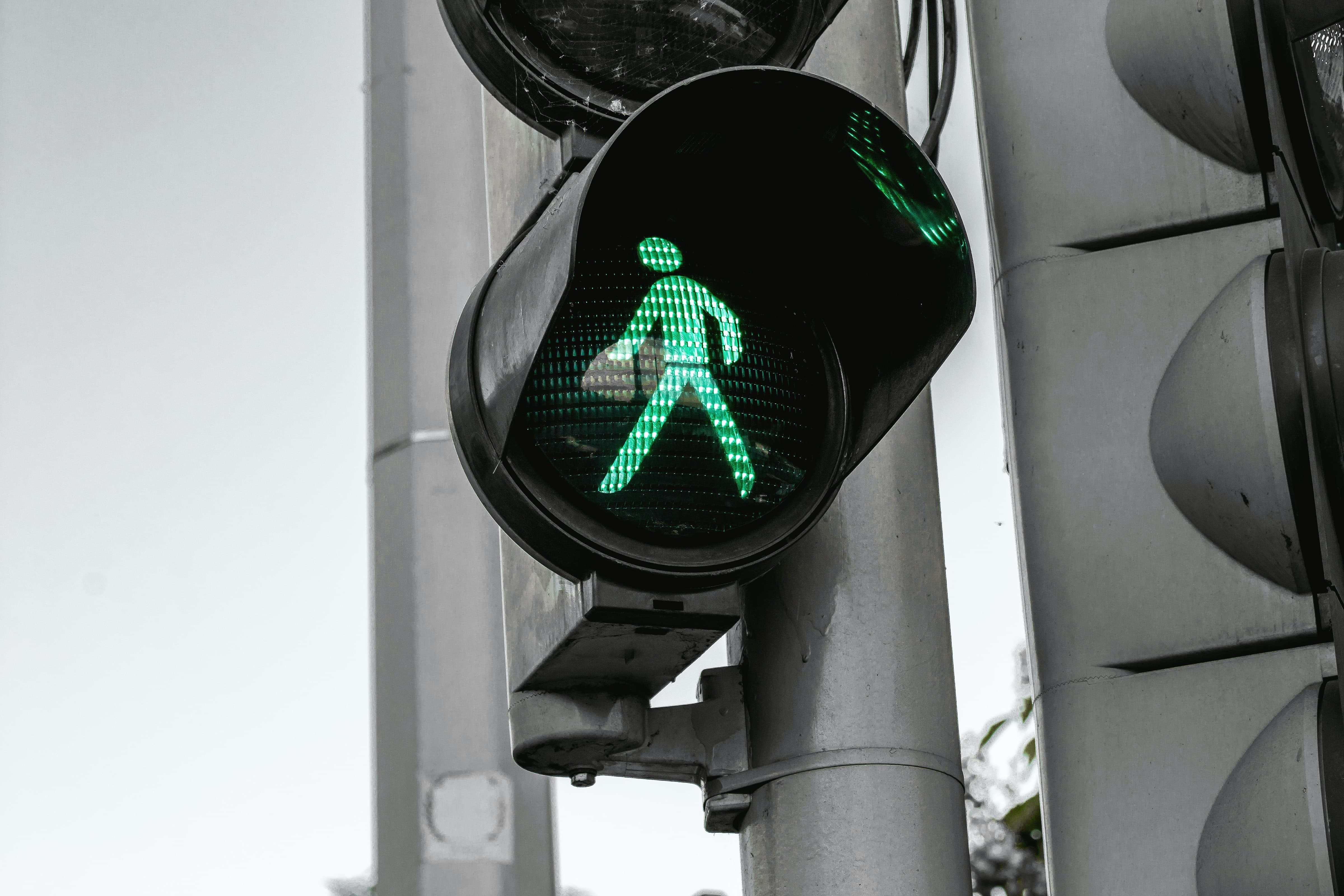 A pedestrian traffic light signaling green.